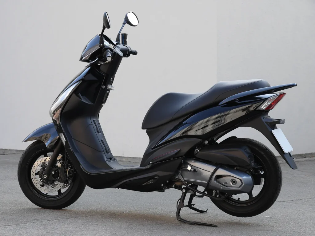 Example of a good listing photograph: a clean scooter side-on in daylight against a plain wall, the whole bike in frame