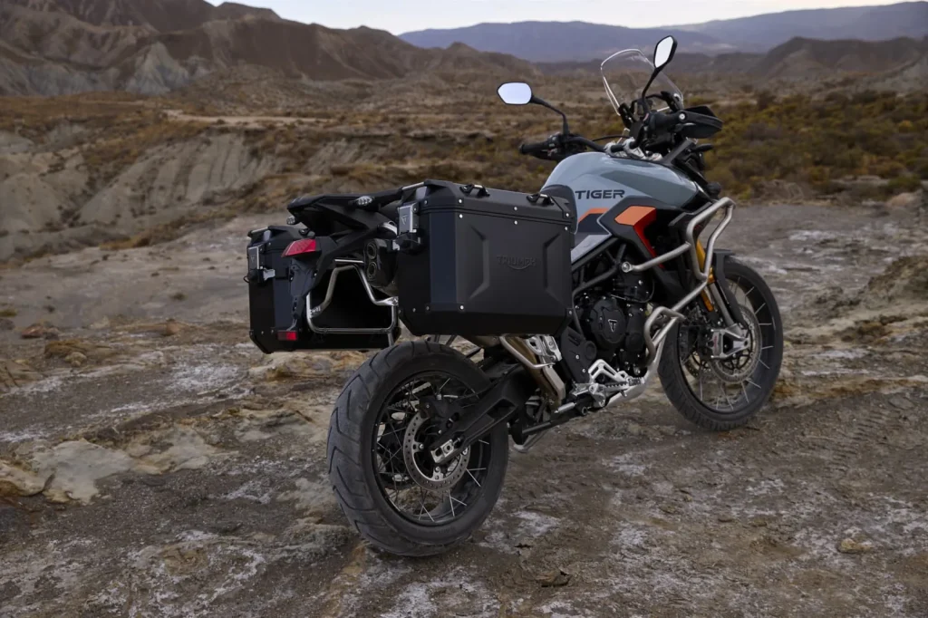 Triumph Tiger 900 Desert Edition with factory panniers fitted, parked on rocky ground