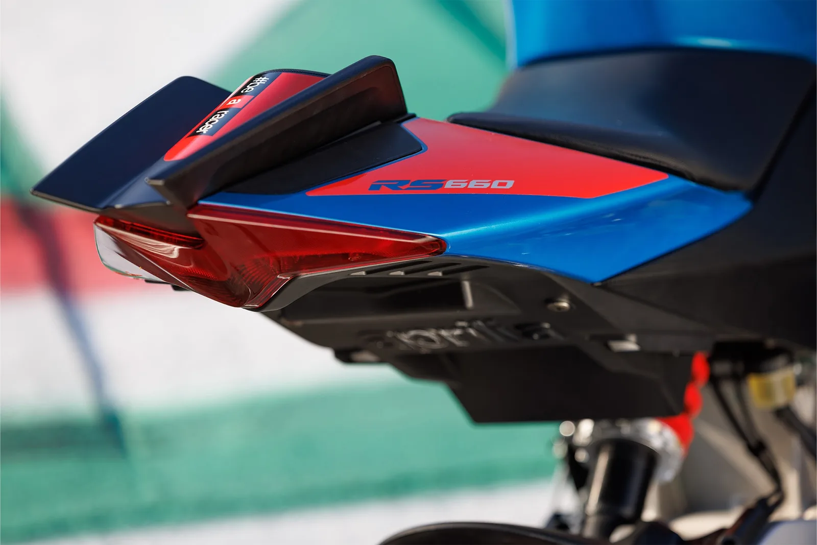 Close-up of the tail unit of a blue and red Aprilia RS 660 Factory showing the rear winglets, LED tail light and RS 660 badge