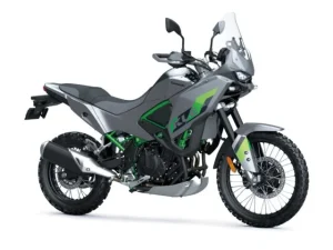 2026 Kawasaki KLE500 SE in Pearl Storm Grey, front three-quarter studio view showing the rally-style fairing, tall windscreen, hand guards, 21 inch spoked front wheel and green trellis frame