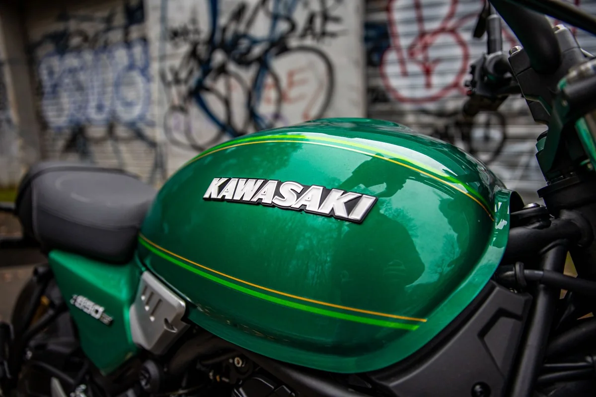 Close-up of the green Kawasaki Z650RS teardrop fuel tank with gold and lime pinstripes and a chrome Kawasaki badge