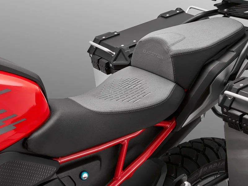 Stepped rider and pillion seat of the QJMotor SRT 600 with grey textured inserts, red trellis subframe and an aluminium pannier and top box fitted
