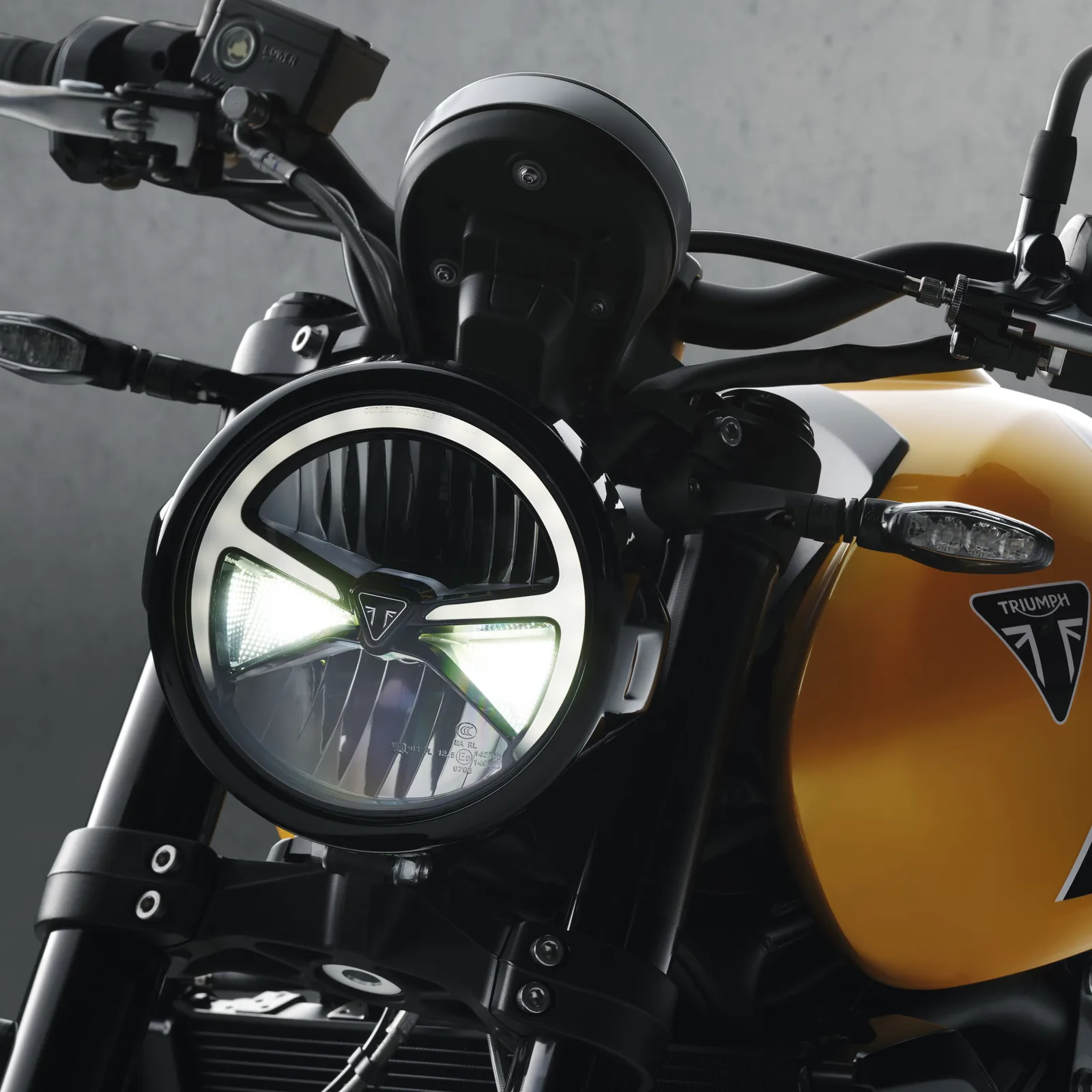 Close-up of the round LED headlight of the 2026 Triumph Trident 660 with its daytime running light ring and black bezel