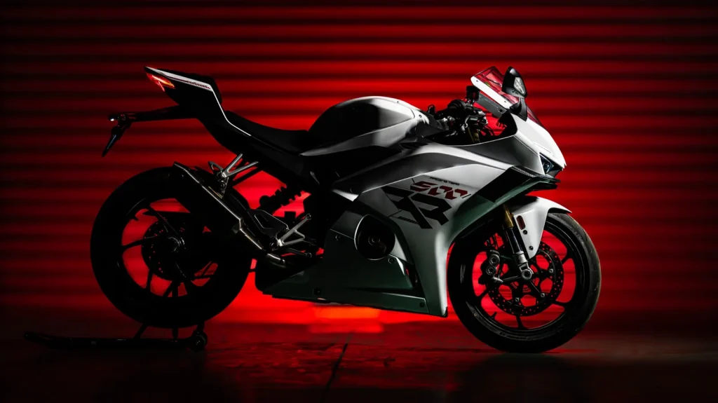 ZXMOTO 500RR sportsbike in white on a paddock stand in a dark studio lit red from behind, showing the single-sided swingarm and winglets